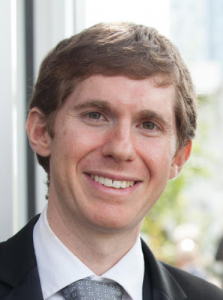 Man with brown hair smiling at the camera.